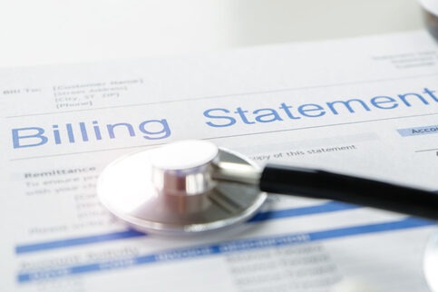 Health care billing statement with stethoscope, bottle of medicine for doctor's work in medical center stone background.