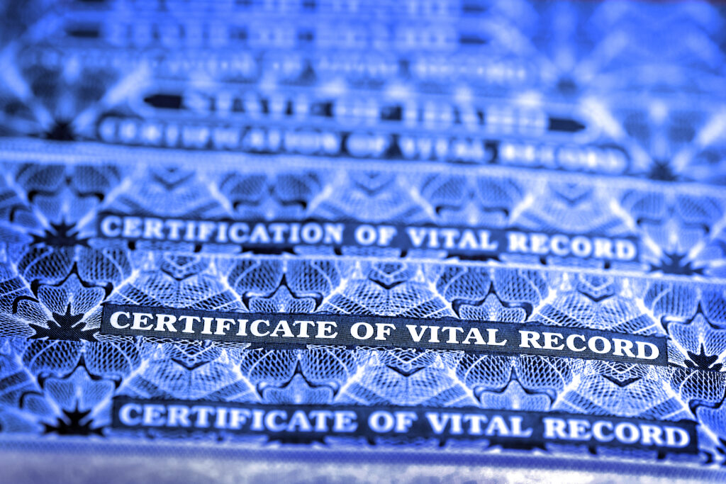 A photo of several stacked birth certificates