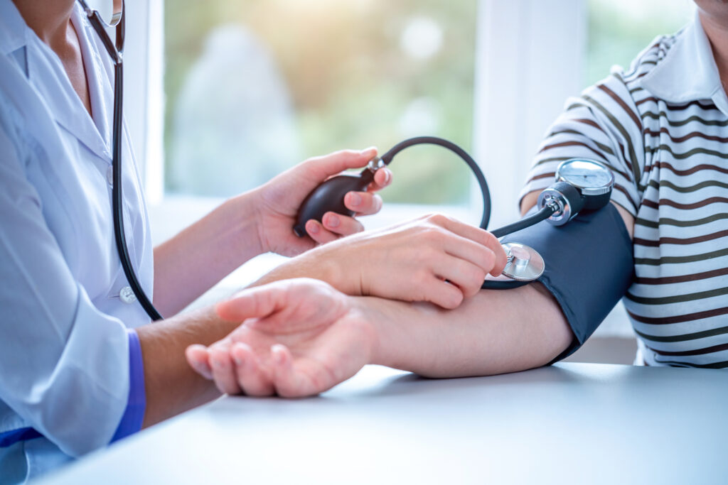 Photo of a doctor measuring the blood pressure of a patient