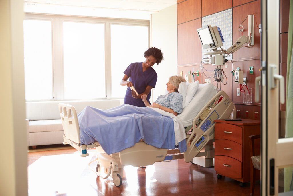 Button for more information on discharge planning consisting of a photo of a nurse speaking with a patient in a hospital bed