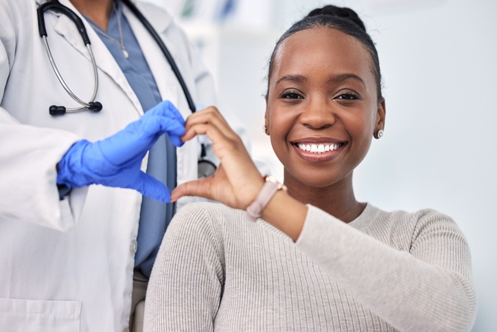 Patient and doctor  forming a heart with their hands
