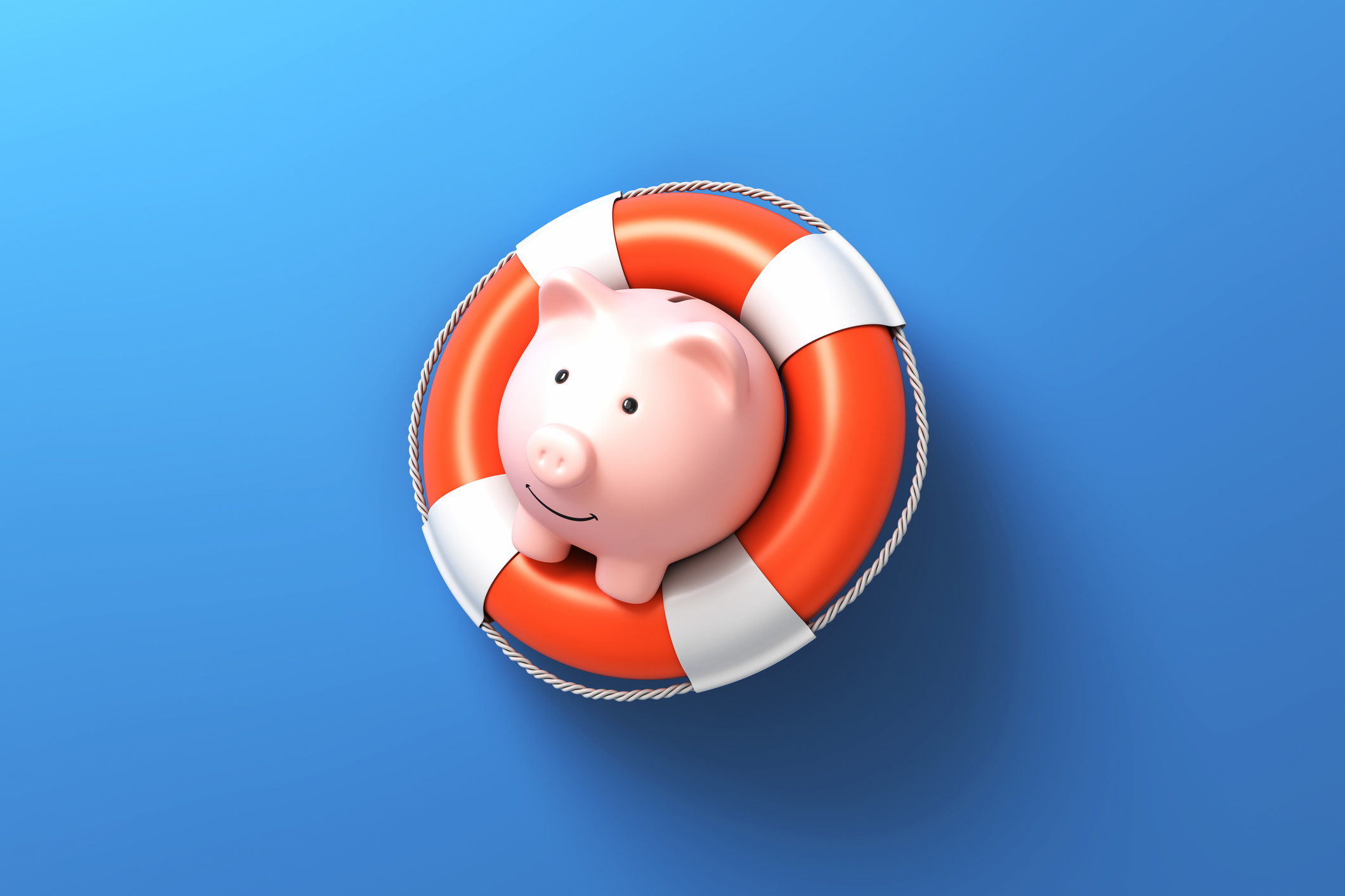 Piggy bank with life buoy on blue background stock photo