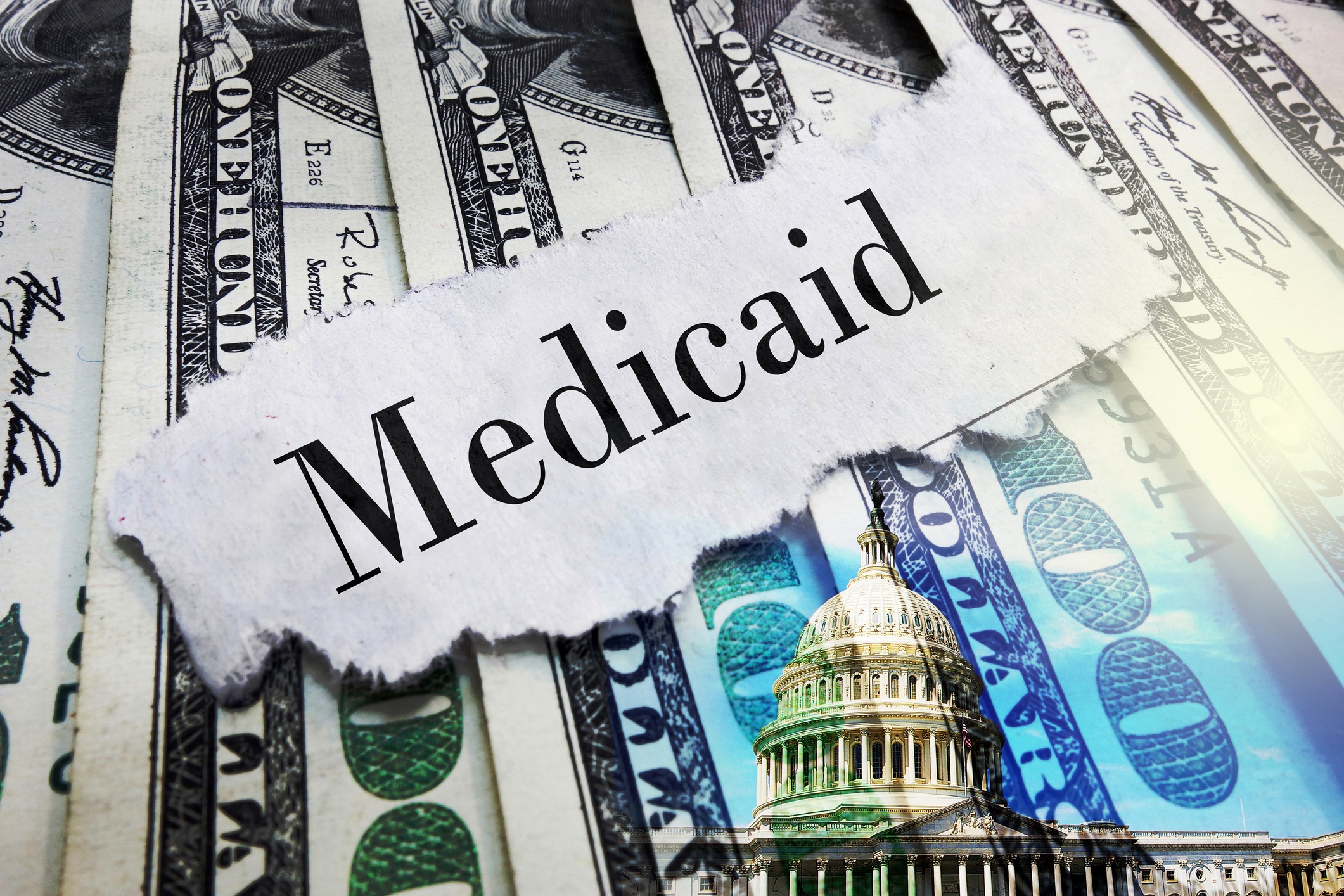 Medicaid newspaper headline on hundred dollar bills with US Capitol in Washington DC