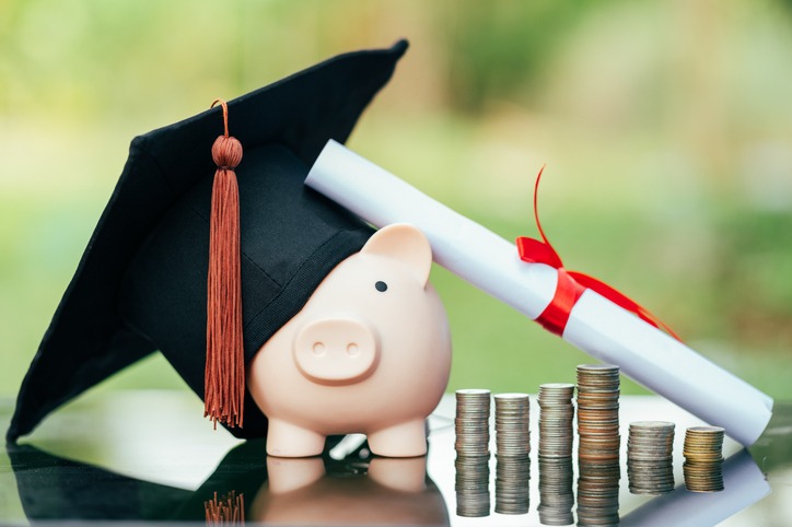 Piggy bank With Graduation Cap on black glass floor