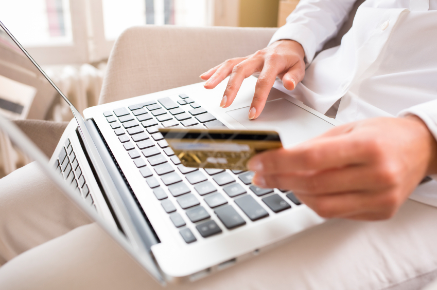 A photo a a woman making a payment by credit card via her laptop