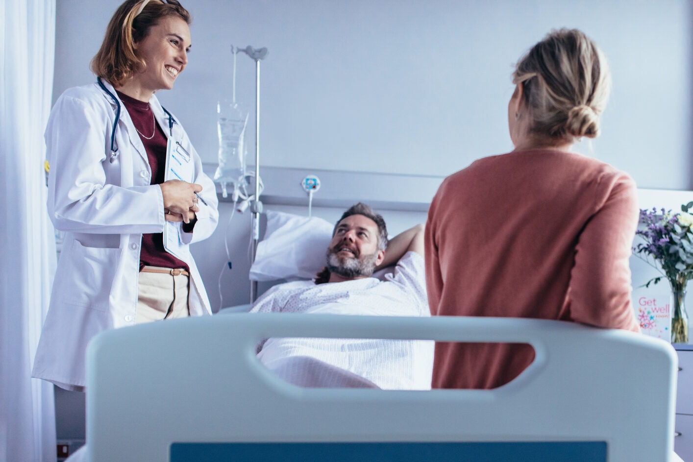 A photo of family and friends visiting a patient in the hospital