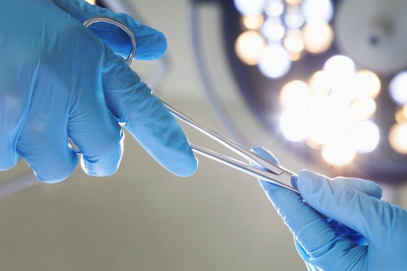 Close-up of gloved hands passing the surgical scissors, operating room, hospital